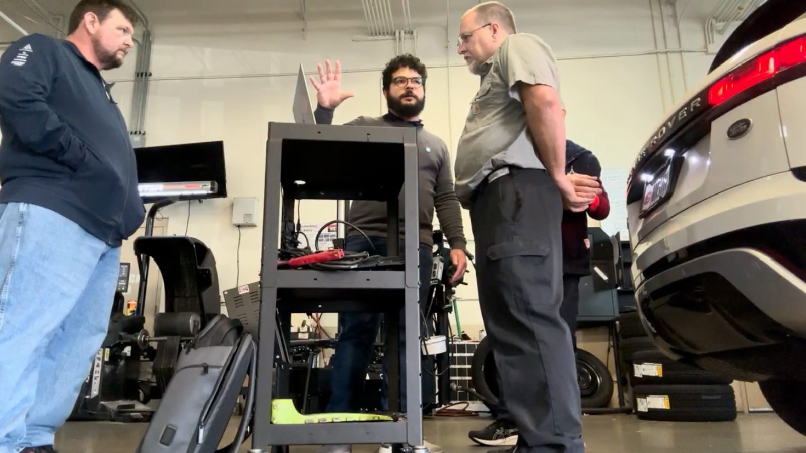 A wider view of a shop workspace during a research visit, with equipment and vehicles in the background